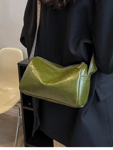 Olive green faux leather crossbody pillow bag with jacquard strap shown on model