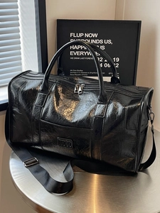 Bolso de viaje de cuero negro con textura arrugada brillante y correa ajustable