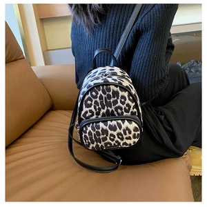 Close-up of leopard print mini backpack with metal fashion bags logo and silver hardware
