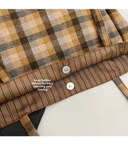Detail of magnetic snap closure on vintage plaid canvas tote bag with striped lining
