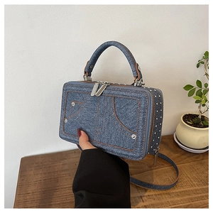 Detailansicht der blauen Denim-Handtasche mit Kontrastnähten und Metallnieten-Verzierung