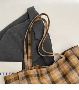 Detail of durable shoulder straps and magnetic clasp on vintage plaid tote bag