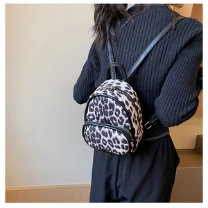 Detail shot of mini leopard print backpack with metal logo and zipper pocket for women