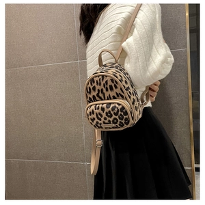 Fashionable leopard print mini backpack shown from a side view on a model