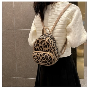 Mini leopard print backpack with faux fur texture styled on a model in a casual outfit