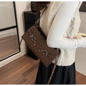 Detail of dark brown baguette shoulder bag with silver buckles and adjustable strap