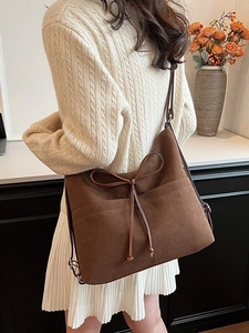 Vintage dark brown frosted tote bag with bow detail on a white knit sweater model