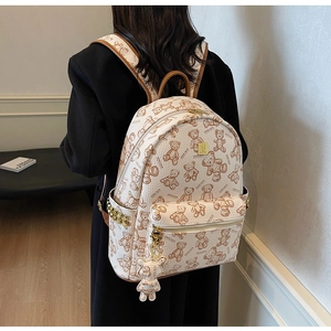 Detail eines beigen Rucksacks mit Teddybären-Druck und luxuriöser Kieselleder-Textur