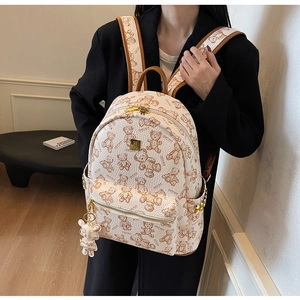 Details des cremefarbenen Lederrucksacks mit Vintage-Bärendruck und Metallbeschlägen