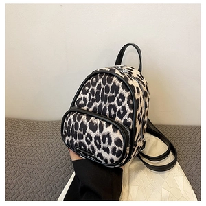 Detailed macro view of a mini leopard print backpack with black trim and silver logo