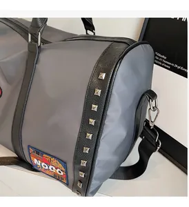 Detail of travel bag showing silver rivets on trim and the NOCO embroidered badge