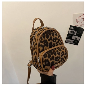 Detail view of leopard print mini backpack with brown trim and silver hardware