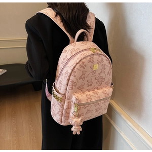Detail eines rosa Rucksacks mit Bärenprint, Goldnieten und passendem Bären-Anhänger