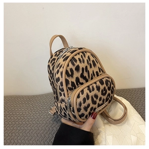 Detail of leopard print faux fur mini backpack with brown leather trim and metal zippers