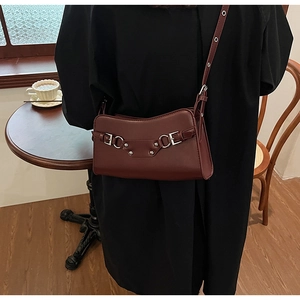 Dark wine red faux leather baguette bag shown as a shoulder carry with silver hardware