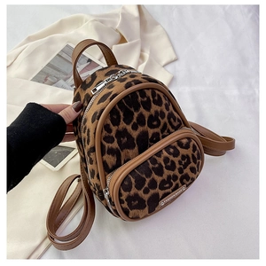 Close-up of leopard print faux fur backpack with brown leather trim and zipper details