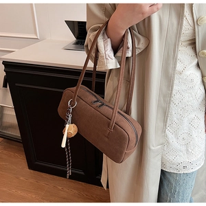 Braune Wildleder-Baguette-Tasche kombiniert mit Trenchcoat in minimalistischem Design