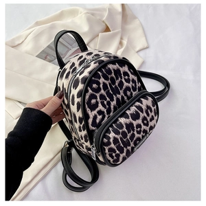 Close-up of leopard print mini backpack with silver zippers and black shoulder straps