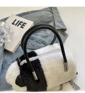 Detail of plush panda handbag featuring soft faux fur texture and silver metal chain strap