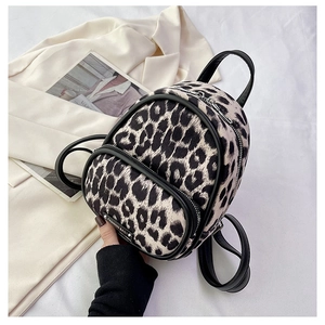 Detail of leopard print mini backpack featuring plush fabric texture and metal zippers