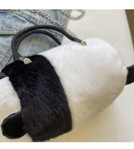 Detailed view of the soft faux fur texture and leather handle of panda plush handbag