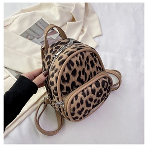 Detail of trendy leopard print mini backpack with contrast faux leather handles and silver zippers