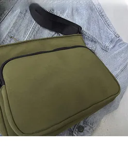 Détail du sac bandoulière vert olive avec fermeture éclair noire et tissu en nylon