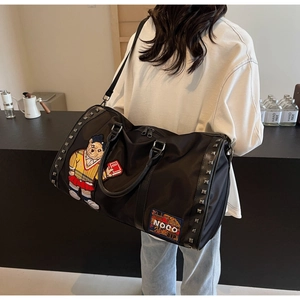 Detail of black travel bag with cartoon bear embroidery and metallic stud accents