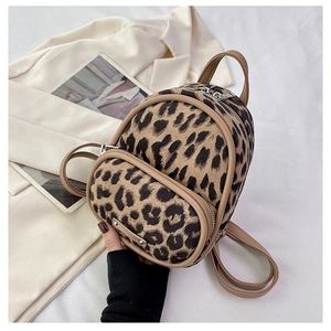 Detail of leopard print plush mini backpack with khaki leather trim and silver zippers