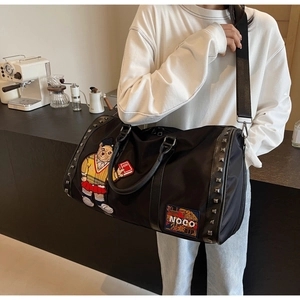 Detail of black travel bag with cartoon bear embroidery and silver rivet accents