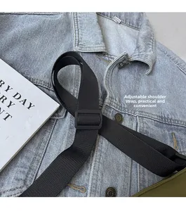 Gros plan sur la bandoulière en nylon réglable avec boucle en plastique du sac à bandoulière