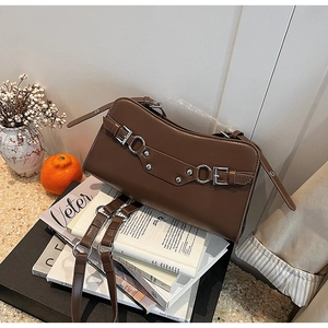 Detail of brown faux leather baguette bag with silver rivets and metal ring decor