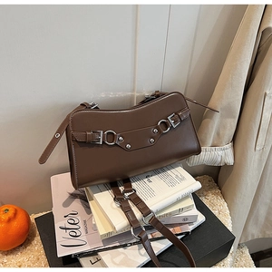 Detail of dark brown baguette bag with silver buckles and smooth leather texture