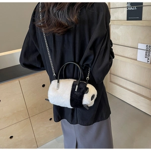Rear view of a model wearing the panda plush bag with silver chain and black handle