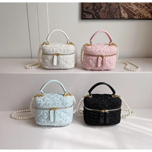 Détail de sacs seaux en tweed en quatre couleurs avec bandoulières perles et zips dorés