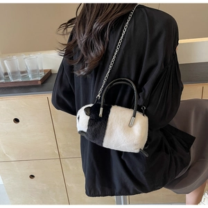 Cute panda plush cylinder bag with silver chain strap shown in a lifestyle cafe setting
