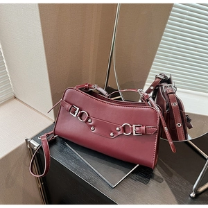 Detail of burgundy leather baguette bag featuring silver hardware and adjustable strap