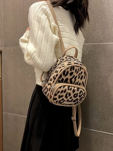 Mini leopard print backpack with brown faux fur and beige leather straps on a model