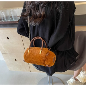 Detail of plush Capybara bag featuring golden chain strap and brown faux leather handle
