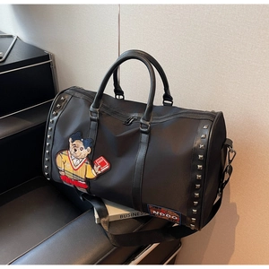Close-up of black travel bag featuring cartoon bear embroidery and silver rivet details