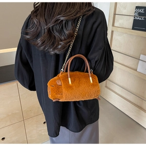 Brown plush capybara bag with golden chain strap shown from a back carry view