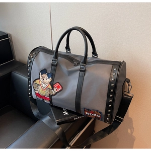 Detail view of gray travel bag featuring silver studs and teddy bear embroidery patch