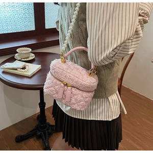 Détail du sac seau en tweed rose avec bandoulière en perles et finitions dorées chic