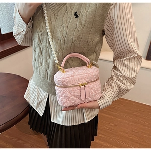 Détail du sac seau rose en fourrure avec bandoulière perle et double zip doré