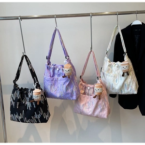 Detail of four colorful tote bags with embroidered wavy texture and plush charms