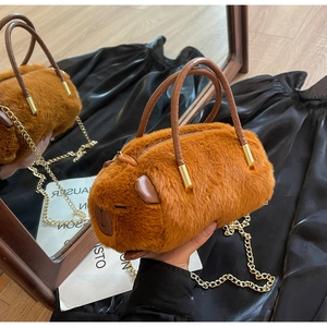 Close-up of a plush capybara bag featuring soft fur texture and golden metal chain strap