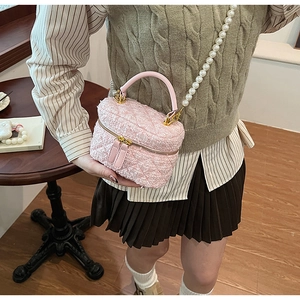 Sac seau en tweed rose avec bandoulière perle élégante et détails dorés brillants