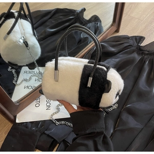 Detail of plush panda handbag with silver metal chain and fluffy faux fur texture