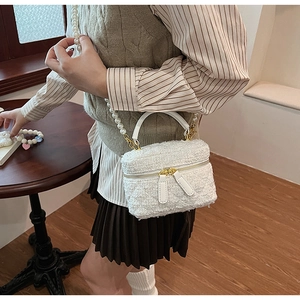 Détails de texture tweed blanc sur sac seau avec bandoulière élégante en chaîne de perles
