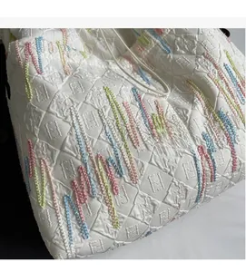Detail showing jacquard fabric texture with colorful wave embroidery and embossed patterns